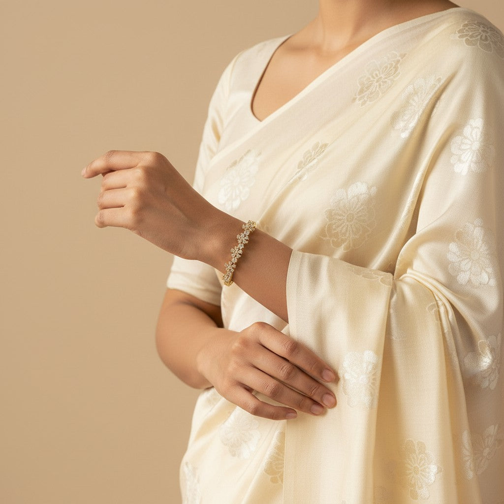 Aurevia Fashion Jewellery Balenna oval cubic zirconia bangle worn on the wrist of a woman in a cream floral saree.