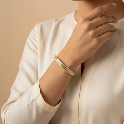 Aurevia Fashion Jewellery gold tone bangle featuring a sparkling cubic zirconia pave setting on a woman's wrist