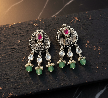 Aurevia Fashion Jewellery Jhansi Aura oxidized silver earrings with pink stones, white kundan, and green bead dangles.