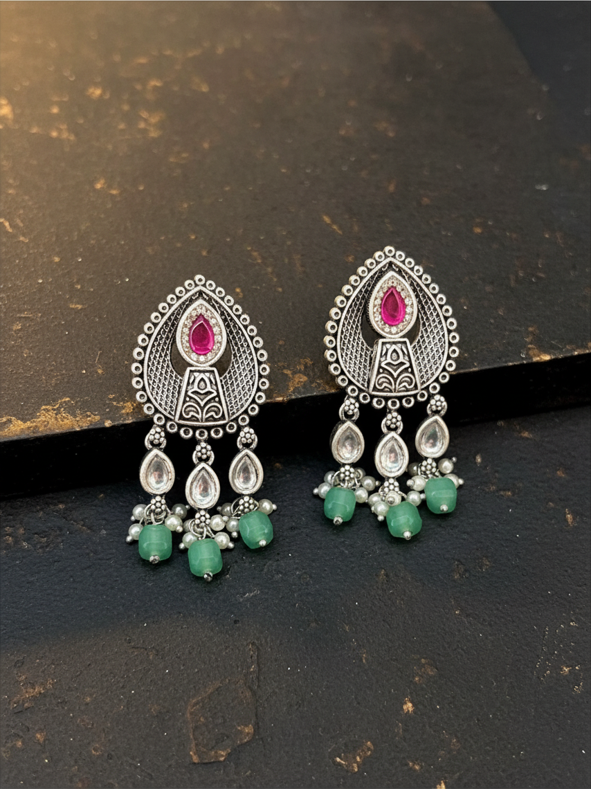 Aurevia Fashion Jewellery Jhansi Aura silver-toned drop earrings with pink stones, clear crystals, and green beads.