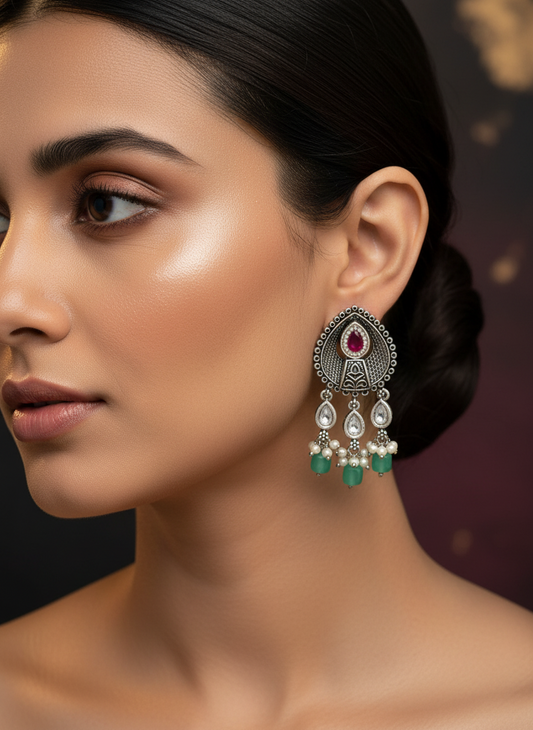 Aurevia Fashion Jewellery Jhansi Aura oxidized silver drop earrings with red stone, clear crystals, and green beads.