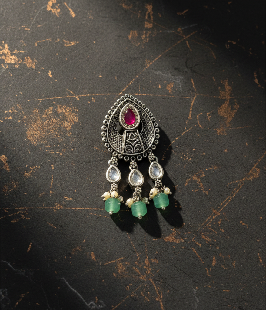 Aurevia Fashion Jewellery Jhansi Aura oxidized silver pendant with a central ruby, white stones, and green beads.
