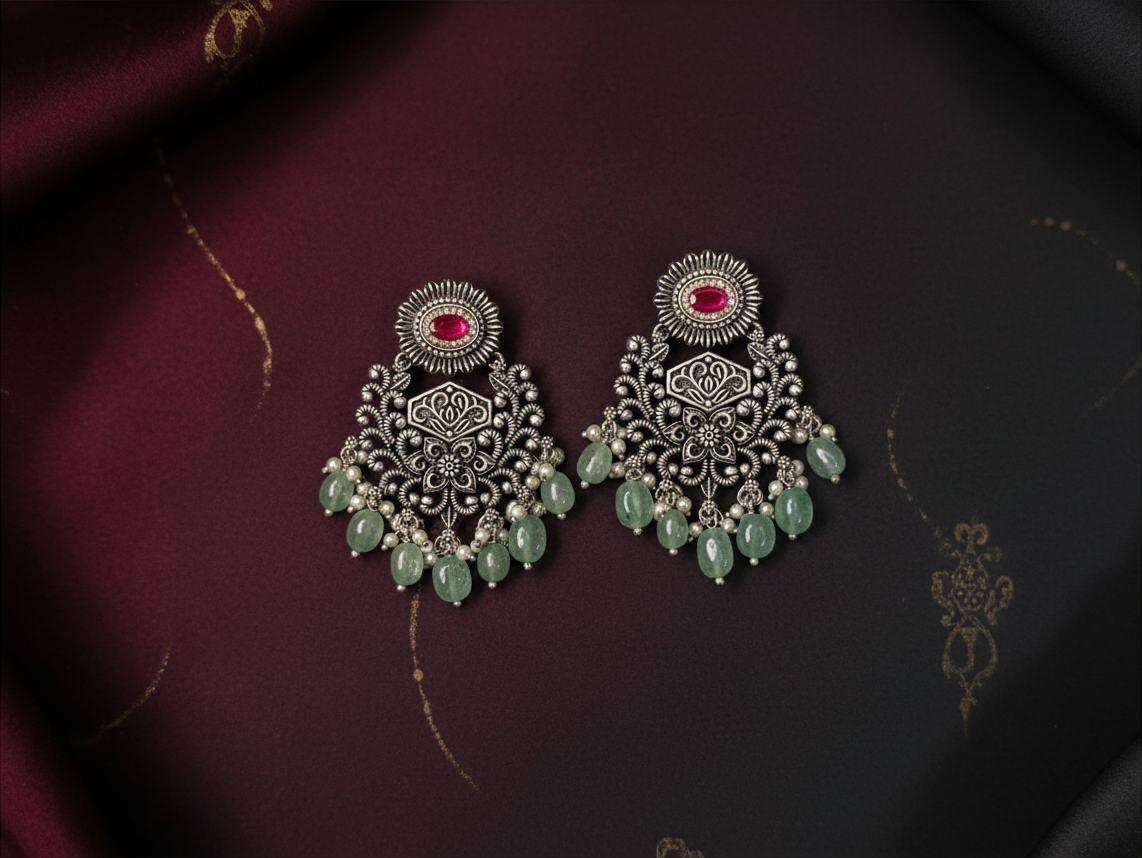 Aurevia Fashion Jewellery Jhansi Grace oxidized silver earrings with pink center stones and hanging green beads.