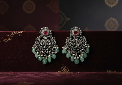 Aurevia Fashion Jewellery Jhansi Grace oxidized silver earrings with pink stones, green beads, and pearl accents.