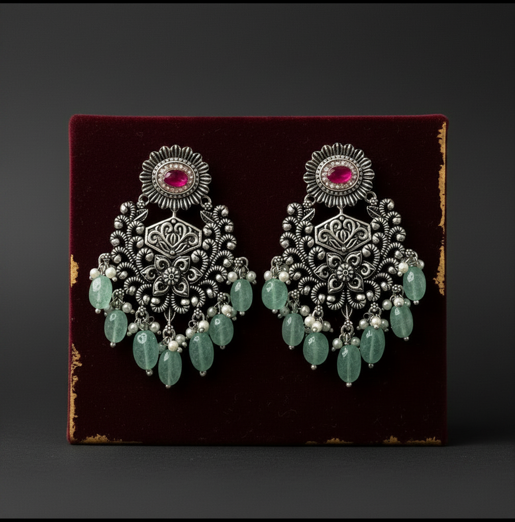 Aurevia Fashion Jewellery Jhansi Grace oxidized silver chandelier earrings with pink stones and green bead dangles.
