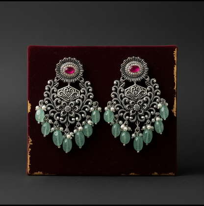 Aurevia Fashion Jewellery Jhansi Grace oxidized silver chandelier earrings with pink stones and green bead dangles.