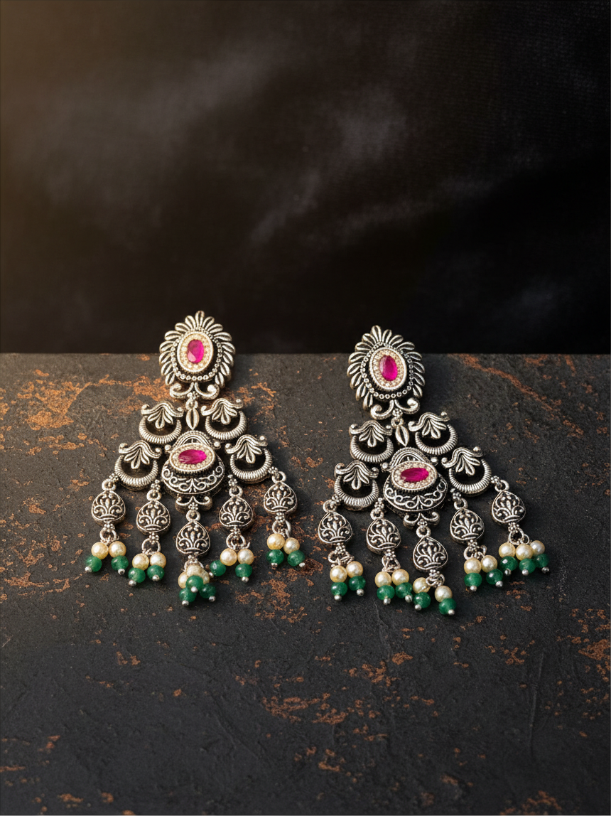 Aurevia Fashion Jewellery Jhansi Heritage silver oxidized earrings with pink stones, white pearls, and green beads.