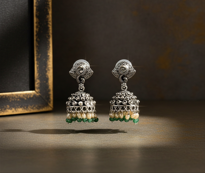Aurevia Fashion Jewellery Jhansi Noor silver jhumka earrings with intricate metalwork, white pearls, and green beads.