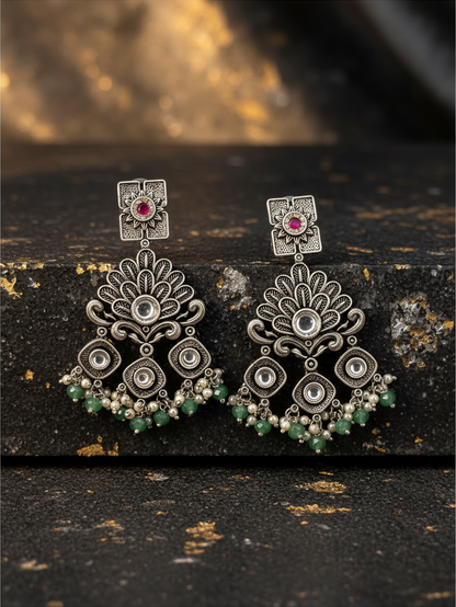 Aurevia Fashion Jewellery Jhansi Regal oxidized silver chandelier earrings with pink stones and green bead accents.