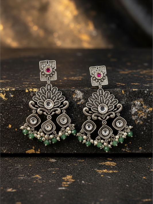 Aurevia Fashion Jewellery Jhansi Regal oxidized silver chandelier earrings with pink stones and green bead accents.