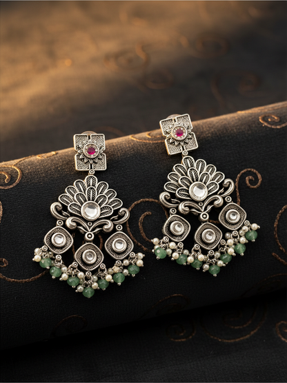 Aurevia Fashion Jewellery Jhansi Regal silver-toned drop earrings with floral motifs, pink stones, and green beads.