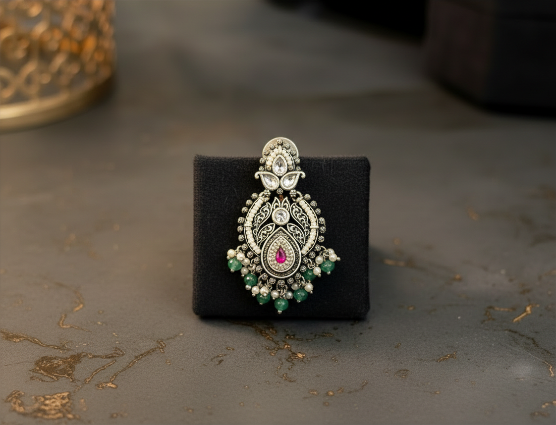Aurevia Fashion Jewellery Jhansi Royale silver-toned earring with intricate filigree, pink stone, and green beads.
