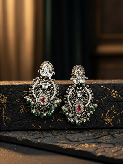Aurevia Fashion Jewellery Jhansi Royale silver-toned ethnic earrings with red stone, pearls, and green bead accents.