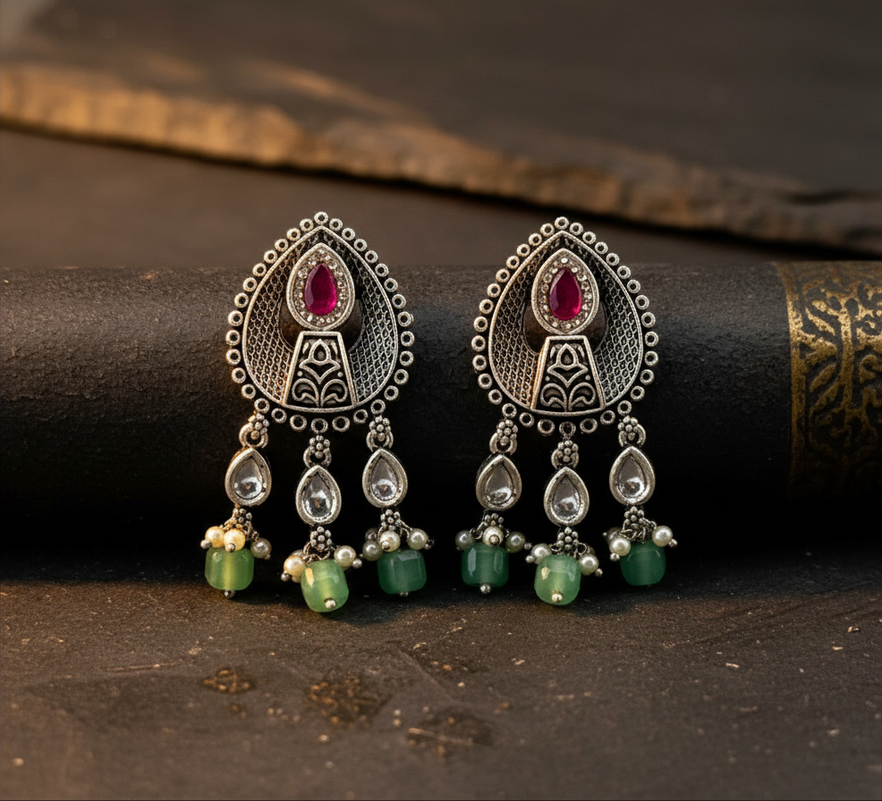Aurevia Fashion Jewellery Jhansi Aura oxidized silver earrings with pink stone, green beads, and pearl accents.
