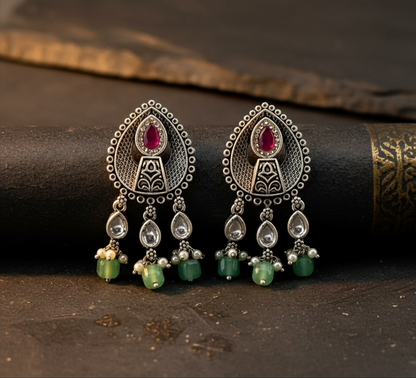 Aurevia Fashion Jewellery Jhansi Aura oxidized silver earrings with pink stone, green beads, and pearl accents.