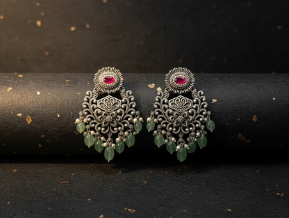 Aurevia Fashion Jewellery Jhansi Grace oxidized silver earrings with pink stones and dangling green bead accents.
