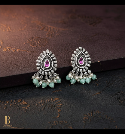 Aurevia Fashion Jewellery Jhansi Majesty oxidized silver stud earrings with pink teardrop stones and mint bead dangles.