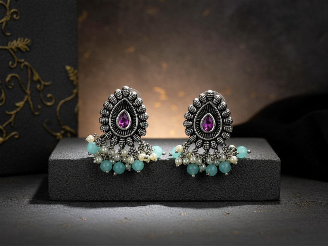 Aurevia Fashion Jewellery Jhansi Majesty oxidized silver stud earrings with purple stones, pearls, and turquoise beads.