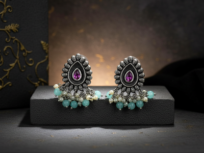 Aurevia Fashion Jewellery Jhansi Majesty oxidized silver stud earrings with purple stones, pearls, and turquoise beads.