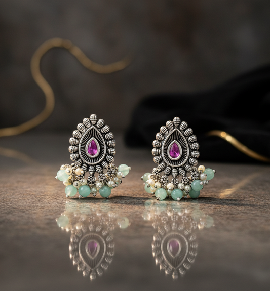 Aurevia Fashion Jewellery Jhansi Majesty oxidized silver stud earrings with pink teardrop stones and mint bead dangles.