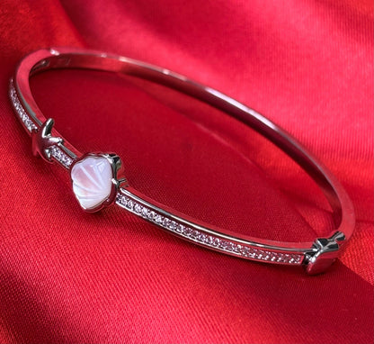 Aurevia Fashion Jewellery bangle featuring a mother of pearl shell, starfish accent, and crystal pavé on red fabric.